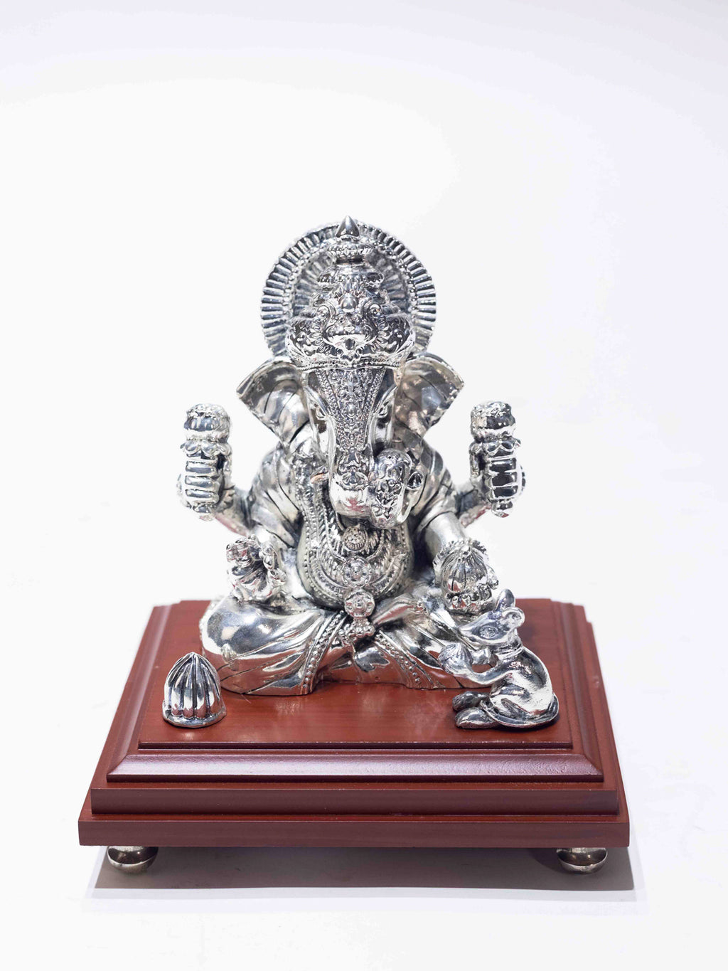 Silver Ganesh Ji Sitting on a Wooden Base