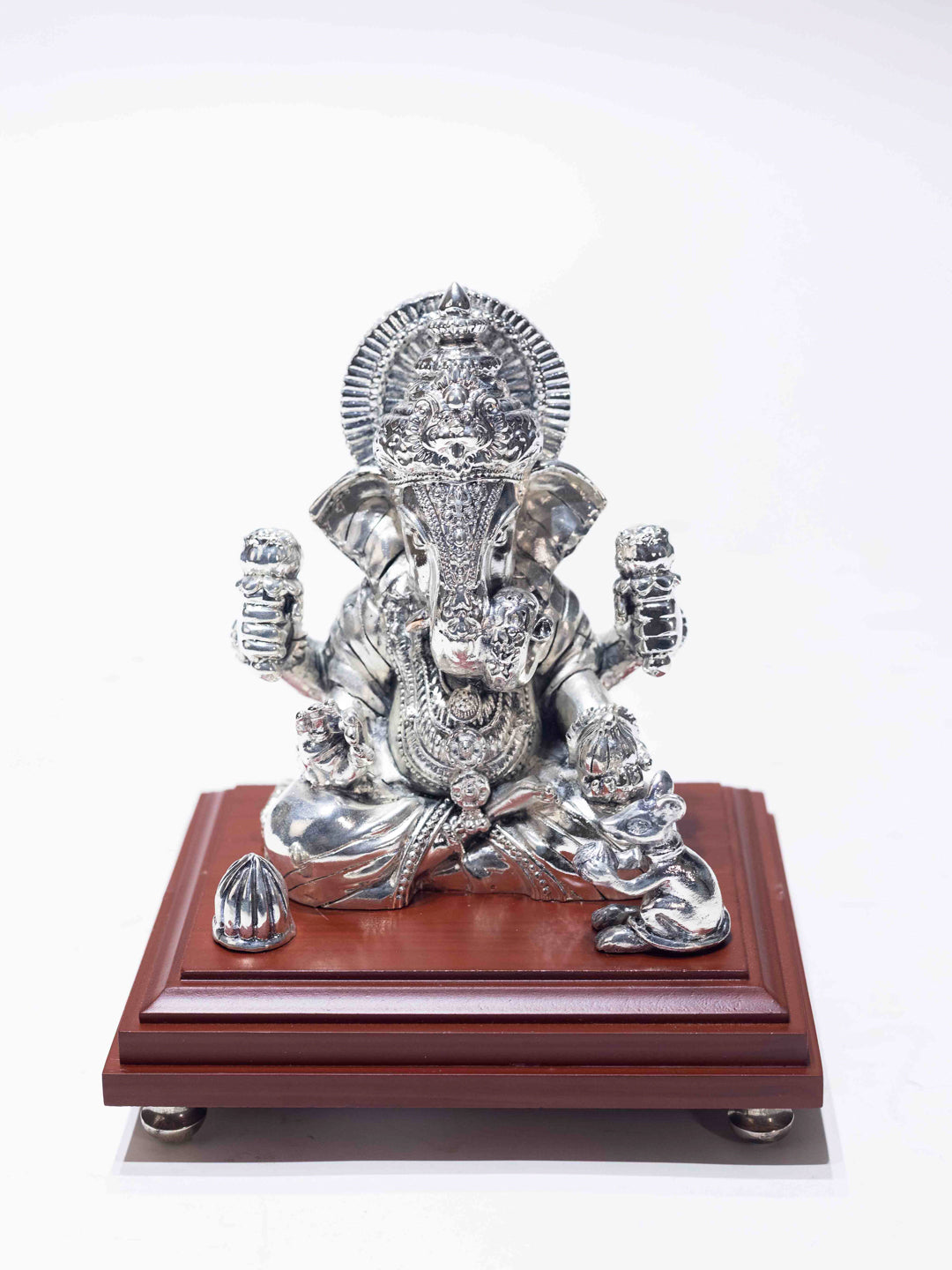 Silver Ganesh Ji Sitting on a Wooden Base