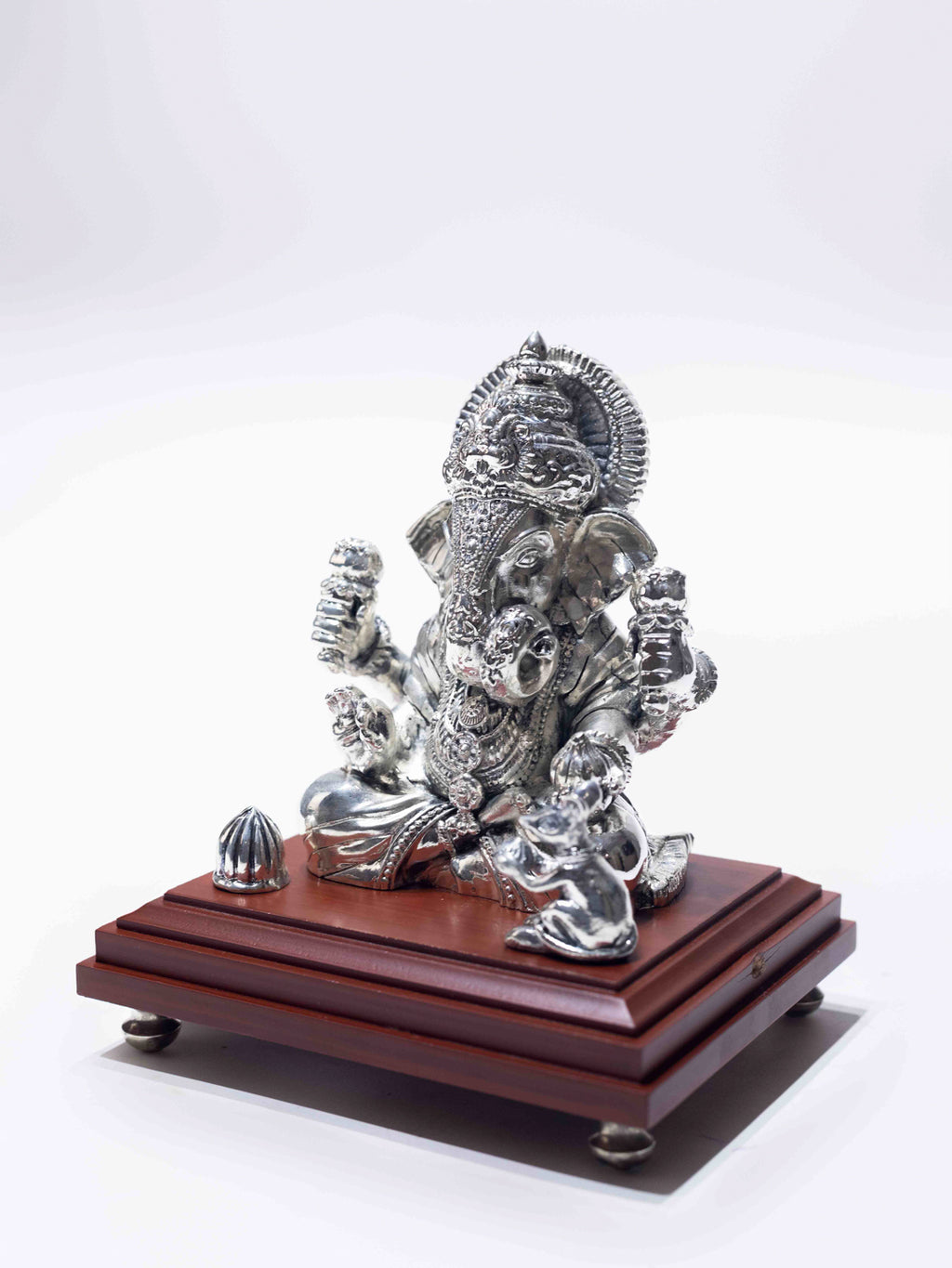 Silver Ganesh Ji Sitting on a Wooden Base
