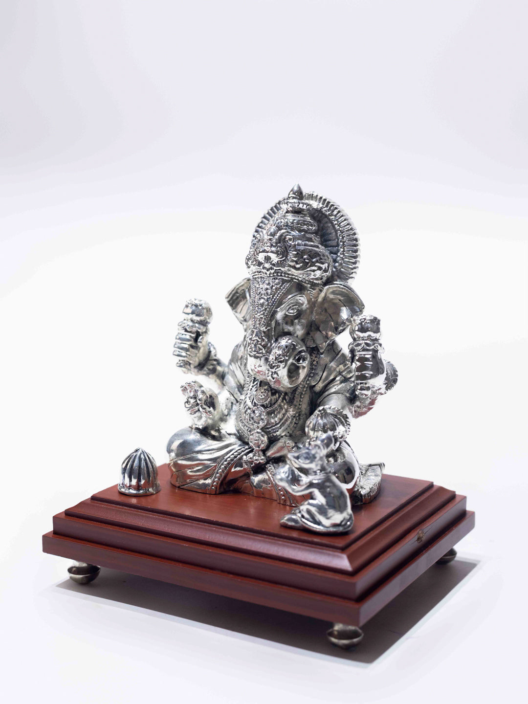 Silver Ganesh Ji Sitting on a Wooden Base